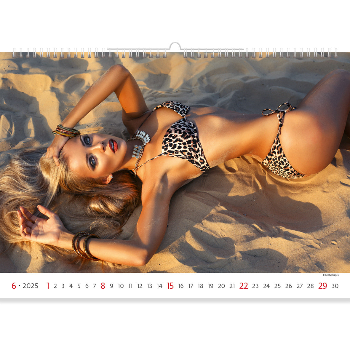 Blonde in a leopard bikini lying on the sand. Sexy Lingerie Calendar 2025 captures her stunning beauty and allure with vibrant beach scenes, blending elegance and sensuality in every month.